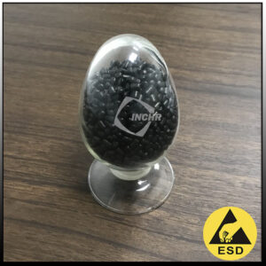 High-resolution close-up of Carbon Fiber Reinforced PC pellets alongside a precision-molded automotive electronic housing, showing the smooth matte surface finish of the finished part